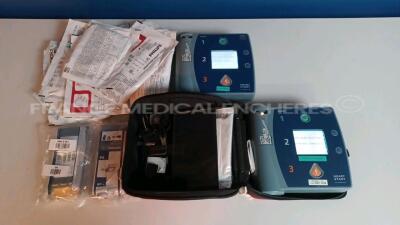 Lot of 2 x Philips Defibrillators Heartstart FR2+ w/ 4 x Philips Batteries (Both power up - French Language) *1011890767/1103104905*